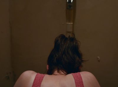 Still from Happening (2021) that has been tagged with: over-the-shoulder & bathroom