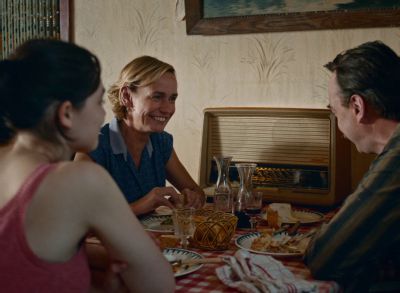 Still from Happening (2021) that has been tagged with: over-the-shoulder & smiling