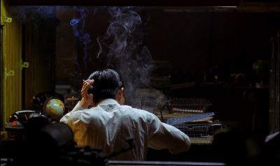 Still from In the Mood For Love (2000) that has been tagged with: over-the-shoulder & fluorescent light