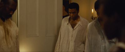 Still from 12 Years a Slave (2013) that has been tagged with: night & interior & group-shot & candles