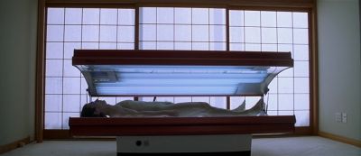 Still from American Psycho (2000) that has been tagged with: tanning bed & wide shot & nudity & day
