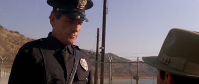 Still from Chinatown (1974) that has been tagged with: chainlink fence & police