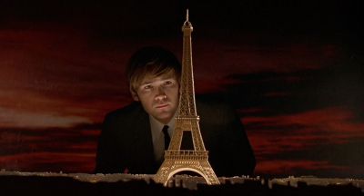 Still from CQ (2001) that has been tagged with: night & medium shot & retro & clean single & interior & eiffel tower