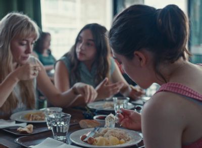 Still from Happening (2021) that has been tagged with: eating & medium shot & over-the-shoulder & cafeteria