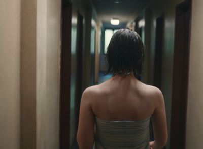 Still from Happening (2021) that has been tagged with: hallway & interior & over-the-shoulder