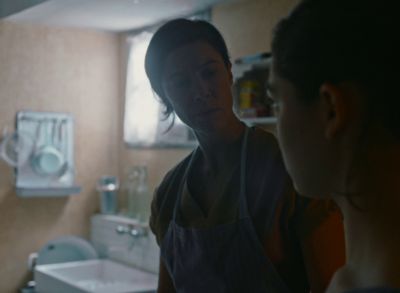 Still from Happening (2021) that has been tagged with: kitchen & over-the-shoulder & interior & day
