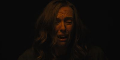 Still from Hereditary (2018) that has been tagged with: 7a3f00 & interior & night & medium close-up