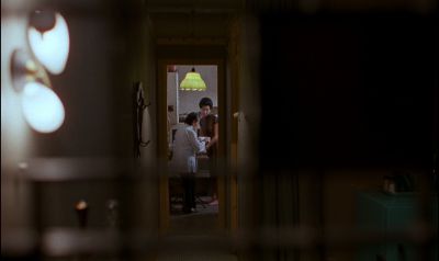 Still from In the Mood For Love (2000) that has been tagged with: practical lamp & wide shot & doorway & hallway