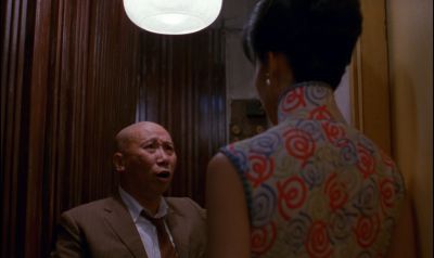 Still from In the Mood For Love (2000) that has been tagged with: 8f5b5b & medium shot & over-the-shoulder & two-shot