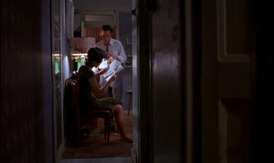 Still from In the Mood For Love (2000) that has been tagged with: two-shot & practical lamp & interior & wide shot & newspaper