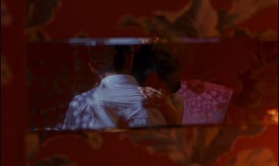 Still from In the Mood For Love (2000) that has been tagged with: night & hug & over-the-shoulder & interior & frame in a frame