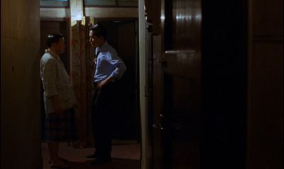 Still from In the Mood For Love (2000) that has been tagged with: wide shot & interior & night & hallway