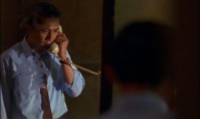 Still from In the Mood For Love (2000) that has been tagged with: over-the-shoulder & phone & night