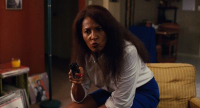 Still from Jackie Brown (1997) that has been tagged with: medium shot & gun & clean single & interior & living room & night