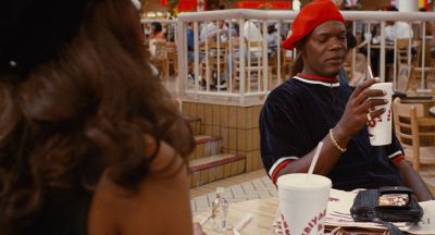 Still from Jackie Brown (1997) that has been tagged with: ad0c00 & over-the-shoulder & table & medium wide & interior