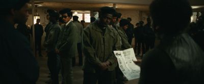 Still from Judas and the Black Messiah (2021) that has been tagged with: interior & night & medium wide & reading & paper