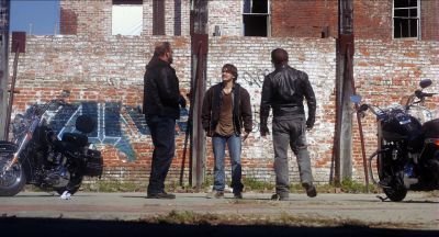 Still from Killer Joe (2011) that has been tagged with: exterior & graffiti & parking lot & over-the-shoulder & motorcycle & brick wall