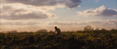Still from Looper (2012) that has been tagged with: field & day & wide shot & clean single