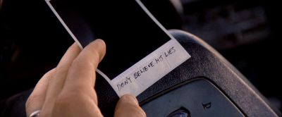 Still from Memento (2000) that has been tagged with: steering wheel & polaroid