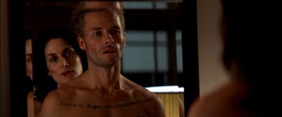 Still from Memento (2000) that has been tagged with: night & medium shot & mirror & interior