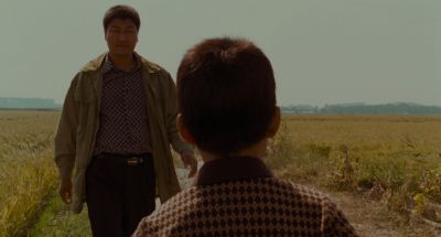 Still from Memories of Murder (2003) that has been tagged with: over-the-shoulder & field & two-shot & medium wide