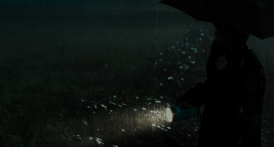 Still from Memories of Murder (2003) that has been tagged with: profile shot & rain & umbrella & flashlight & medium wide