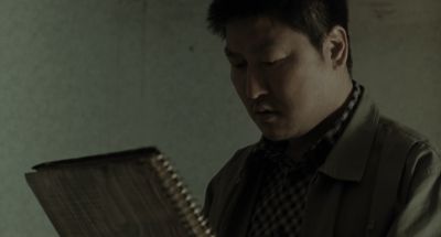 Still from Memories of Murder (2003) that has been tagged with: reading & low-angle & clean single & medium shot