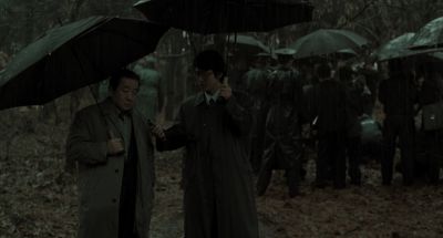 Still from Memories of Murder (2003) that has been tagged with: group-shot & umbrella & two-shot & wide shot