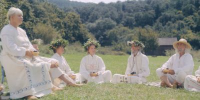 Still from Midsommar (2019) that has been tagged with: 714f38 & exterior & field & group-shot