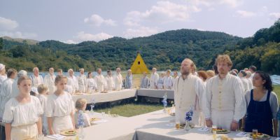 Still from Midsommar (2019) that has been tagged with: group-shot & wide shot & banquet & exterior