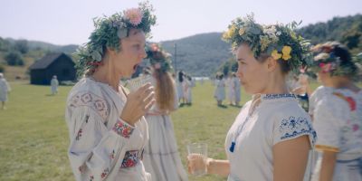 Still from Midsommar (2019) that has been tagged with: 6b8f24 & two-shot & day & profile shot & medium shot
