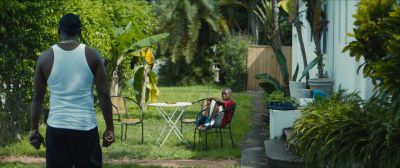 Still from Moonlight (2016) that has been tagged with: wide shot & over-the-shoulder & backyard & exterior & day