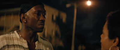 Still from Moonlight (2016) that has been tagged with: over-the-shoulder & medium close-up & night & exterior & street light