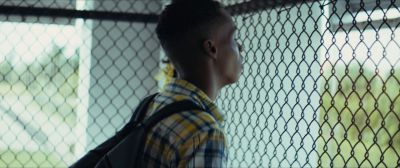 Still from Moonlight (2016) that has been tagged with: over-the-shoulder & chainlink fence & medium shot