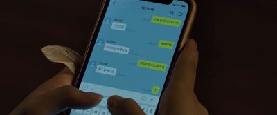 Still from Parasite (2019) that has been tagged with: 6b8f24 & night & insert & extreme close-up & texting