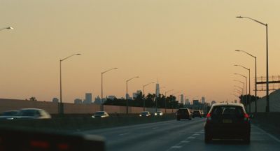 Still from Past Lives (2023) that has been tagged with: exterior & car & highway & wide shot