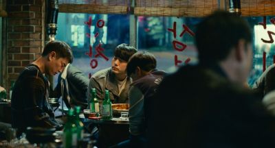 Still from Past Lives (2023) that has been tagged with: wide shot & bar & night & group-shot