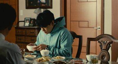 Still from Past Lives (2023) that has been tagged with: eating & interior & two-shot & medium shot