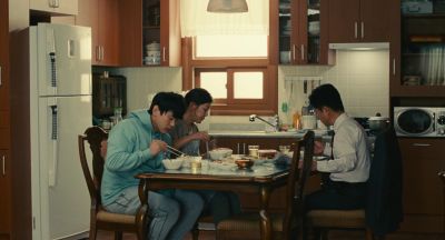 Still from Past Lives (2023) that has been tagged with: day & eating & dinner & wide shot & interior