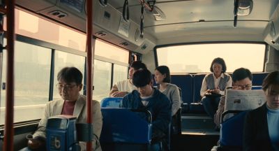 Still from Past Lives (2023) that has been tagged with: wide shot & day & group-shot & reading