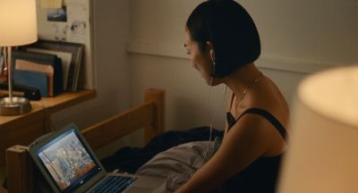 Still from Past Lives (2023) that has been tagged with: interior & laptop & clean single & night