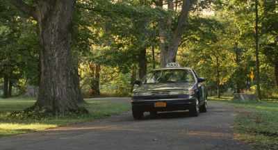 Still from Past Lives (2023) that has been tagged with: day & wide shot & car