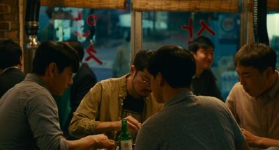 Still from Past Lives (2023) that has been tagged with: over-the-shoulder & interior & bar & group-shot