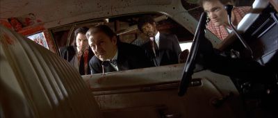 Still from Pulp Fiction (1994) that has been tagged with: 6e1c1c & medium wide & garage & blood & day