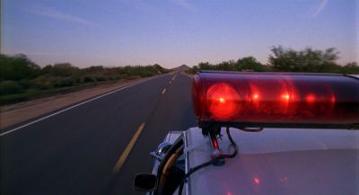 Still from Raising Arizona (1987) that has been tagged with: f4a662 & day & exterior & police car