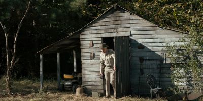 Still from TV Show: Netflix — "Stranger Things: Season 1 - Episode 1" that has been tagged with: wide shot & day & shack