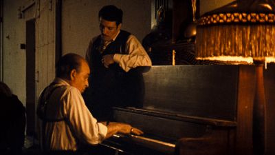 Still from The Godfather (1972) that has been tagged with: 6e1c1c & practical lamp & interior & medium wide & piano