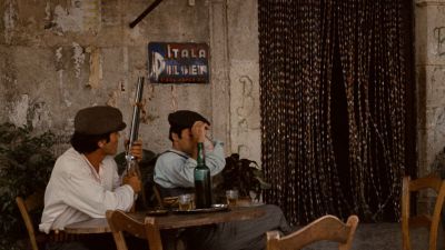 Still from The Godfather (1972) that has been tagged with: table & drinking & wide shot & day