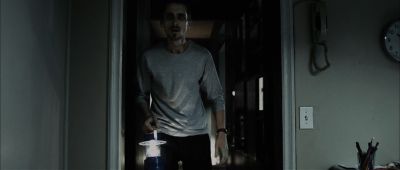 Still from The Machinist (2004) that has been tagged with: medium wide & interior & lantern & doorway & night