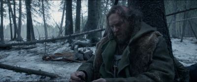 Still from The Revenant (2015) that has been tagged with: exterior & clean single & sitting & forest